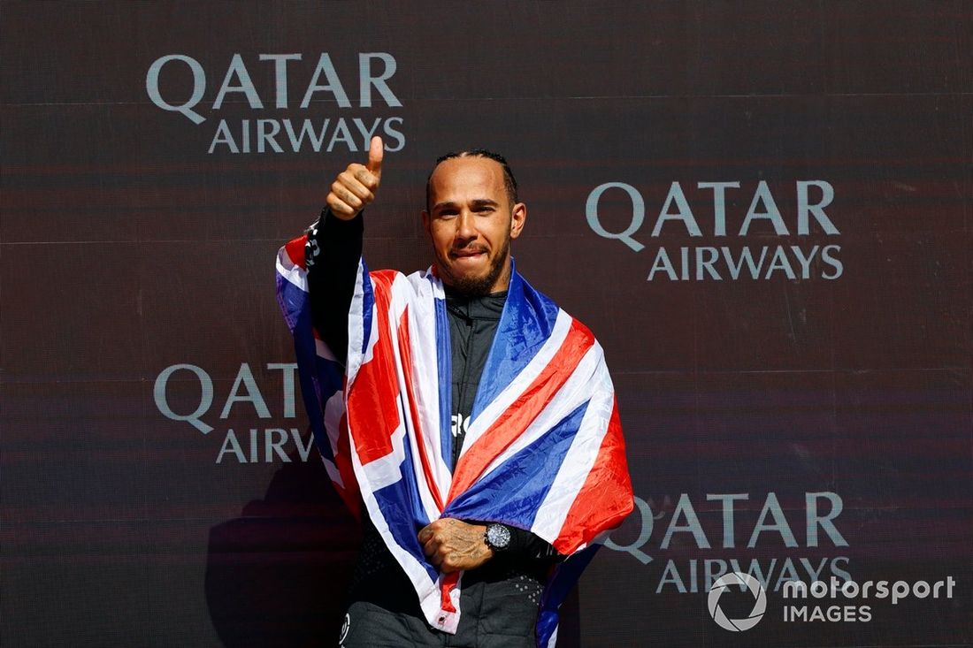 Lewis Hamilton, Mercedes-AMG F1 Team, 1ª posición, lo celebra en el podio con una bandera de la Unión.
