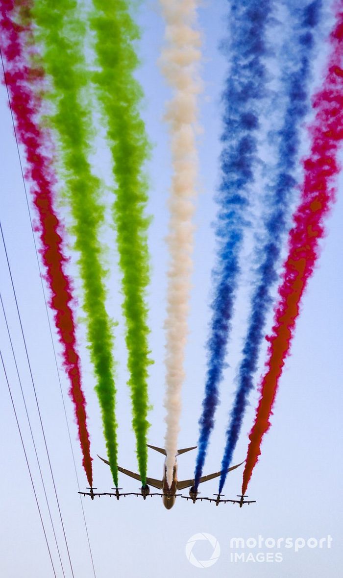 El equipo de exhibición de la Fuerza Aérea de los Emiratos Árabes Unidos Al Fursan escoltan un Boeing 787 Dreamliner en el aire sobre la parrilla, antes de la salida