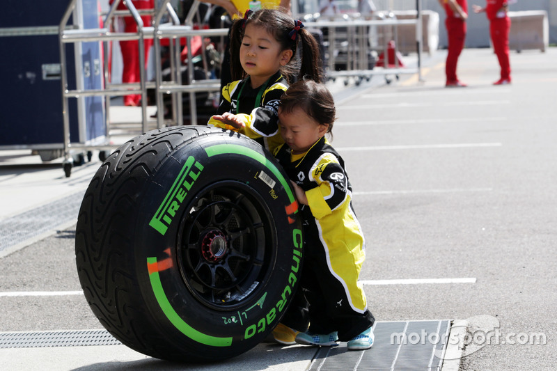 De jeunes fans de Renault Sport F1 Team avec un pneu Pirelli