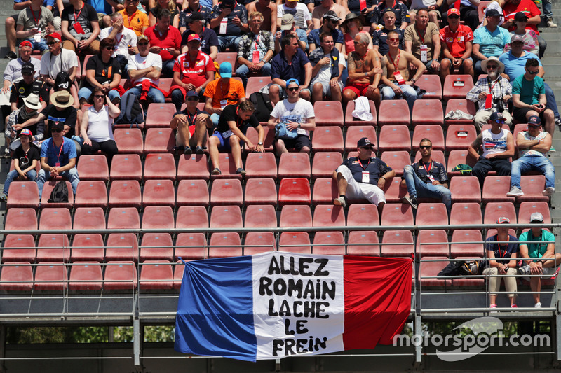 Romain Grosjean, banner de Haas F1 Team con fans en la tribuna