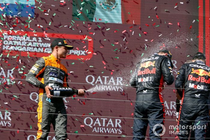 Lando Norris, McLaren, 2ª posición, rocía con champán a Max Verstappen, Red Bull Racing, 1ª posición, Sergio Pérez, Red Bull Racing, 3ª posición, en el podio.