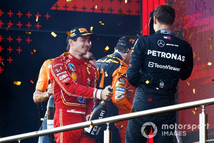 Charles Leclerc, Scuderia Ferrari, 2ª posición, George Russell, Mercedes-AMG F1 Team, 3ª posición, celebran en el podio con champán