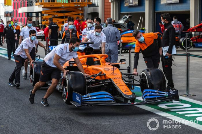Mecánicos de McLaren llevan el coche por el pitlane de Turquía