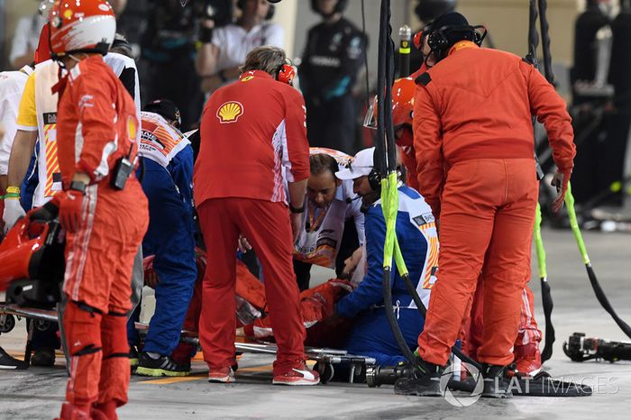 Un mecánico de Ferrari es atendido por médicos después de ser golpeado por el coche de Kimi Raikkonen, Ferrari SF71H durante una parada en boxes