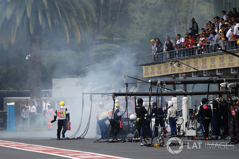 Fire marshals with the car of Marcus Ericsson, Sauber C36 after retiring from the race with a fire