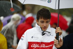 Charles Leclerc, Sauber, shelters from the rain under an umbrella