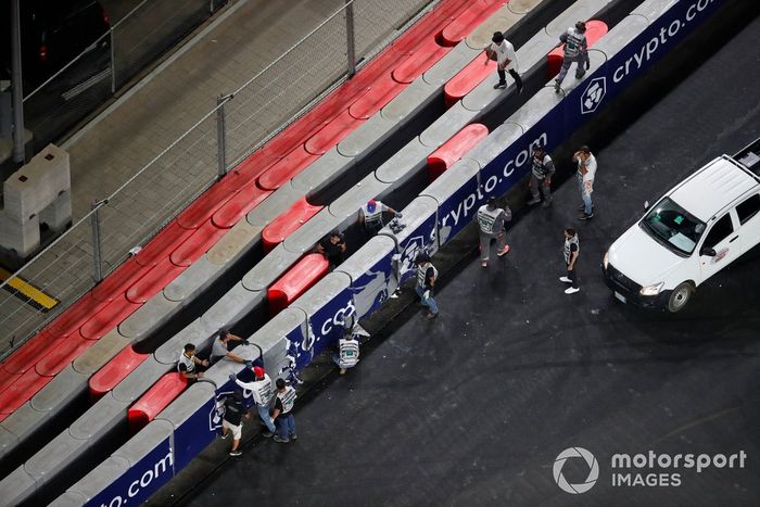 Los oficiales de pista reparan una barrera tras el accidente de Mick Schumacher, Haas VF-21