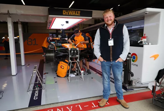 Kaleb Cooper poses for a photo outside the McLaren garage 