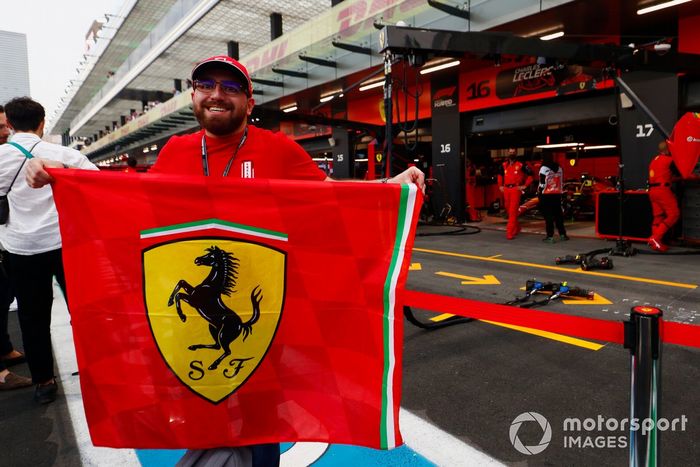 Un fan de Ferrari con una bandera fuera del garaje