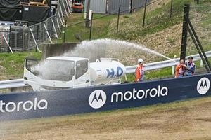 Los alguaciles rocían agua para humedecer la hierba y evitar incendios en las vías.