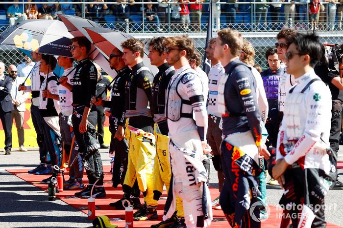 Los pilotos se colocan en la parrilla para escuchar el himno nacional antes de la salida