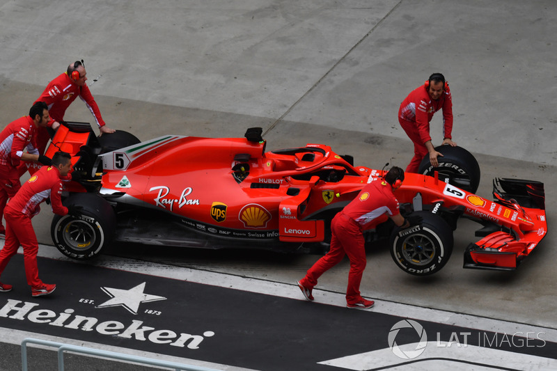 Ferrari mechanics with Ferrari SF71H in pit lane