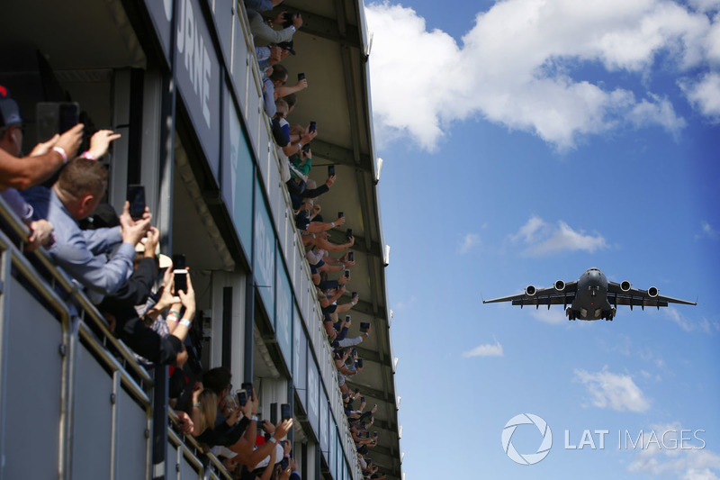 A Royal Australian Air Force Boeing C-17A Globemaster III flies over the grid prior to the start