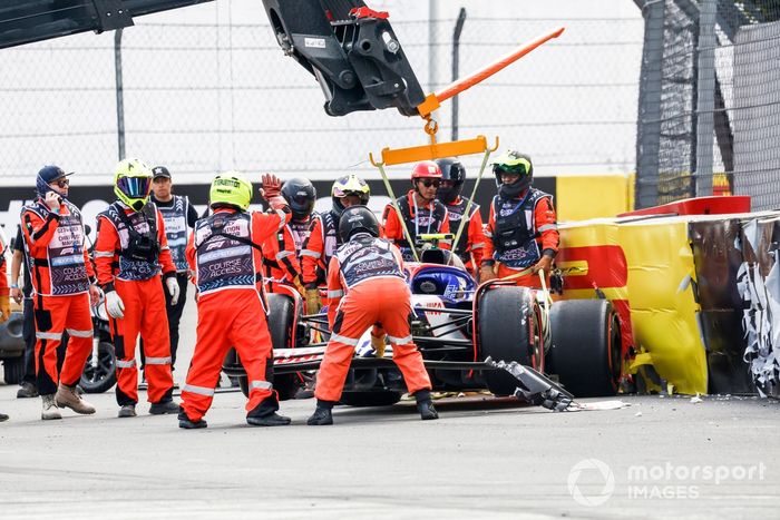 Los comisarios retiran el coche dañado de Yuki Tsunoda, RB F1 Team VCARB 01, de una barrera tras un accidente al final de la Q2.