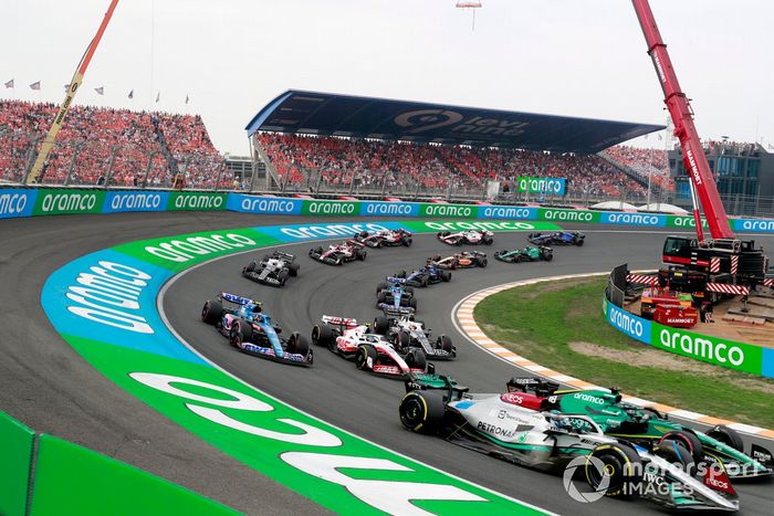 George Russell, Mercedes W13, Lance Stroll, Aston Martin AMR22, Esteban Ocon, Alpine A522, Mick Schumacher, Haas VF-22, Yuki Tsunoda, AlphaTauri AT03, el resto de la parrilla en la primera vuelta