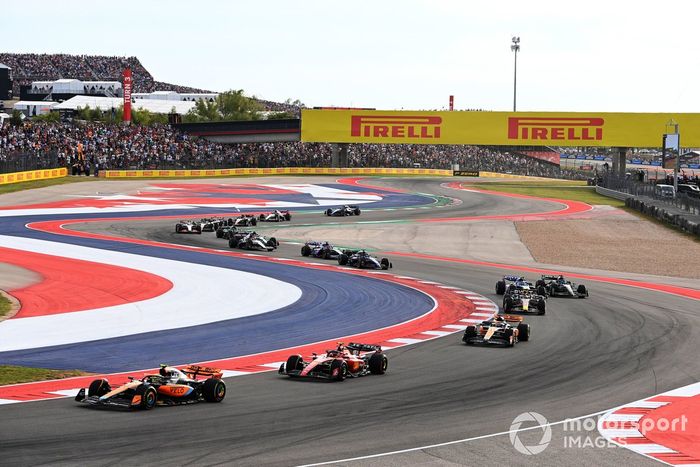 Lando Norris, McLaren MCL60, Carlos Sainz, Ferrari SF-23, Oscar Piastri, McLaren MCL60, Sergio Pérez, Red Bull Racing RB19, el resto de la parrilla en la primera vuelta.