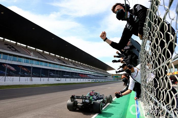 Lewis Hamilton, Mercedes W12, cruza la meta frente a su equipo en el muro de boxes