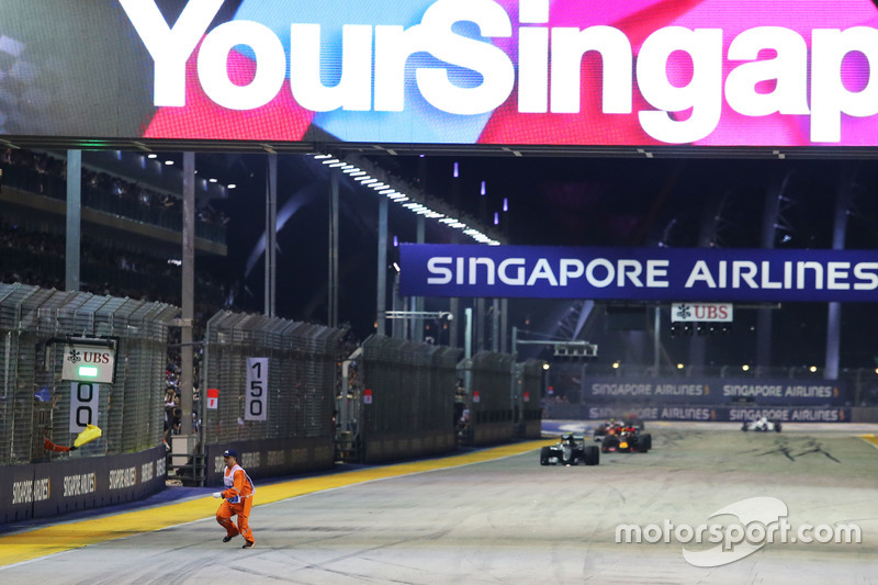 A marshal runs along the circuit as Nico Rosberg, Mercedes AMG F1 W07 Hybrid leads at the restart