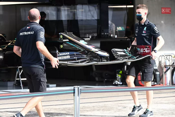 Miembros del equipo Mercedes trabajan en el coche