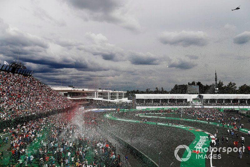 Los aficionados invaden la pista en el podio después de la carrera