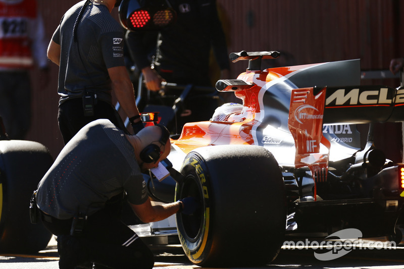 A Pirelli engineer checks a tyre on the Fernando Alonso McLaren MCL32