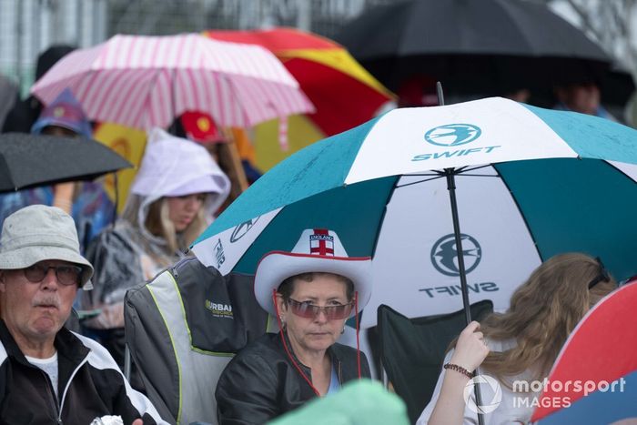 Aficionados bajo paraguas en una tribuna