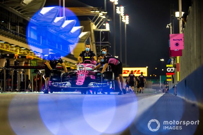 Los mecánicos empujan el Racing Point RP20 de Sergio Pérez a lo largo del pitlane