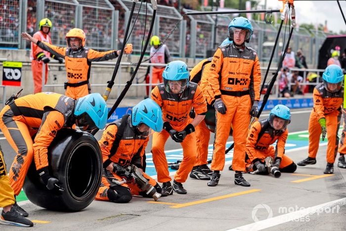 Los miembros del equipo de boxes de McLaren se colocan en posición para una parada