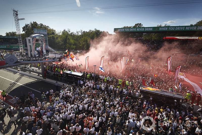 Mercedes team personnel and a huge crowd of Ferrari fans gather for the podium