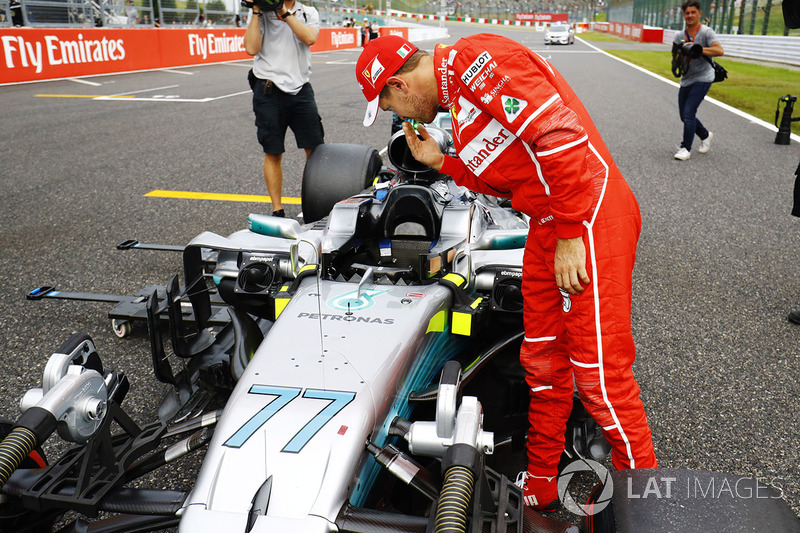 Sebastian Vettel, Ferrari, looks at the car of Valtteri Bottas, Mercedes AMG F1 W08