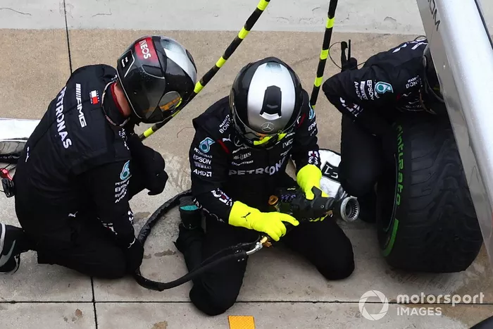 Mecánicos cambiando la rueda en el monoplaza de Mercedes 