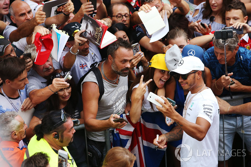 Lewis Hamilton, Mercedes AMG F1, takes a picture for a fan