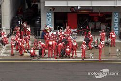 Los miembros del equipo Ferrari preparan área de pits