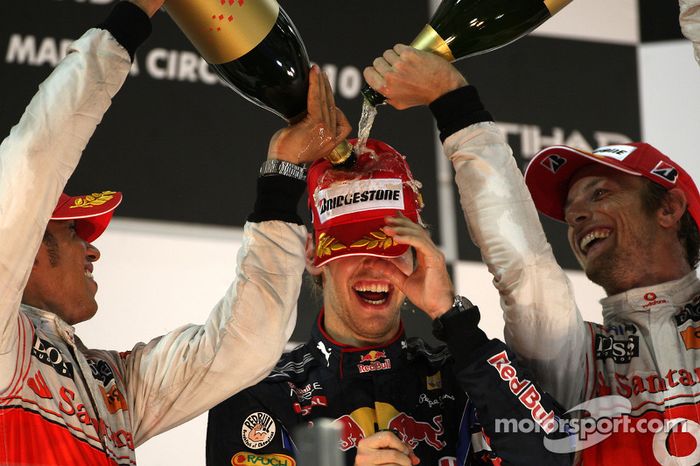 Sebastian Vettel, Red Bull Racing, campeón del mundo de F1 2010, es bañado por Hamilton y Button, de McLaren