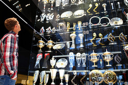 Sebastian Vettel looks olha os troféus na fábrica da Red Bull Racing