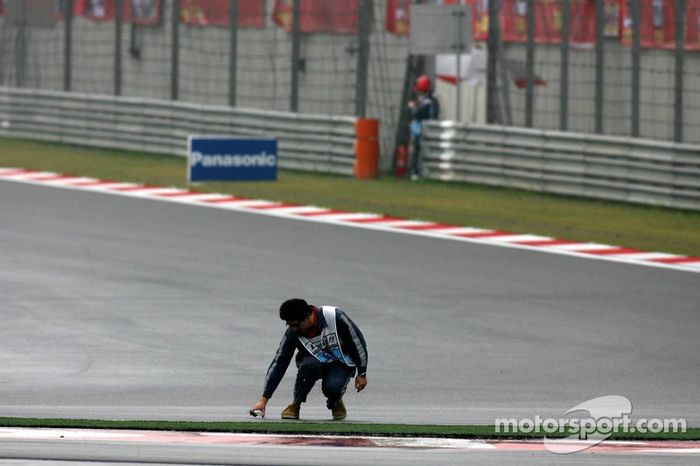 Un comisario recoge algunos restos en el circuito