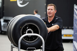 Un mécanicien Lotus F1 Team avec des pneus Pirelli