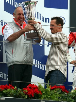 Michael Schumacher da la mano a Ron Dennis y el trofeo de constructores