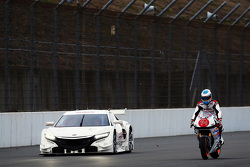 Fernando Alonso pilote une moto Honda à côté d'une Honda NSX