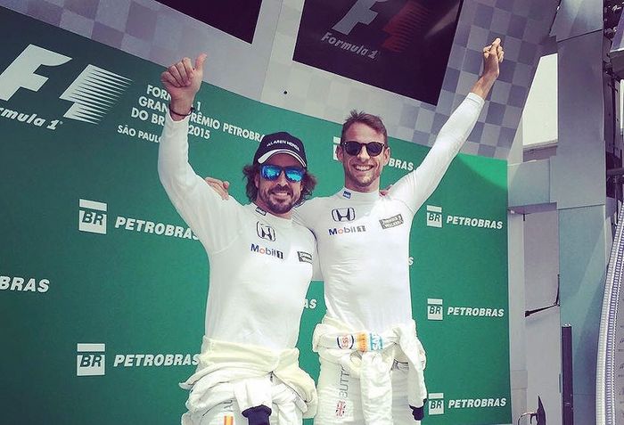 Fernando Alonso y Jenson Button bromean simulando un doblete de McLaren sobre el podio de Interlagos
